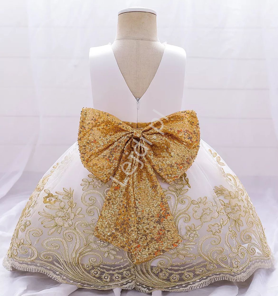 Biała sukienka dla dziewczynki z złotą cekinową kokardą