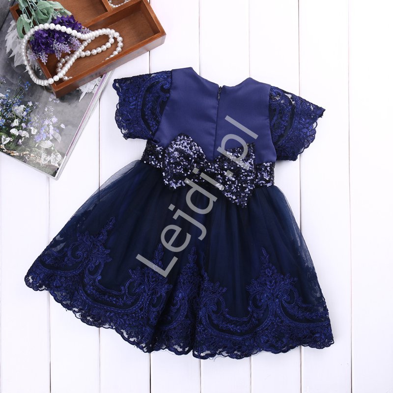 Granatowa sukienka dla dziewczynki zdobiona koronką i cekinową kokardą