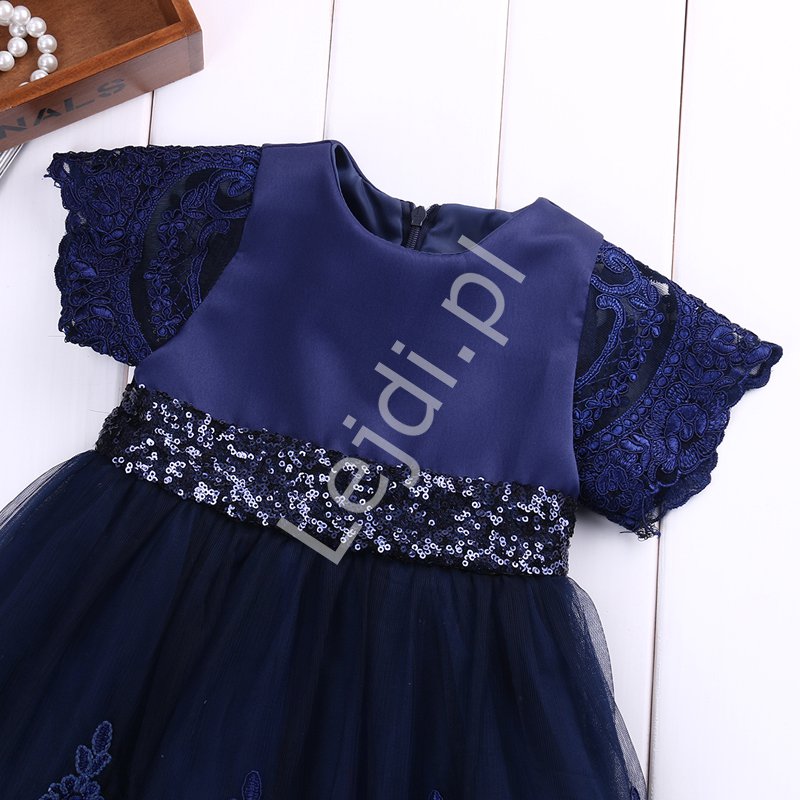 Granatowa sukienka dla dziewczynki zdobiona koronką i cekinową kokardą